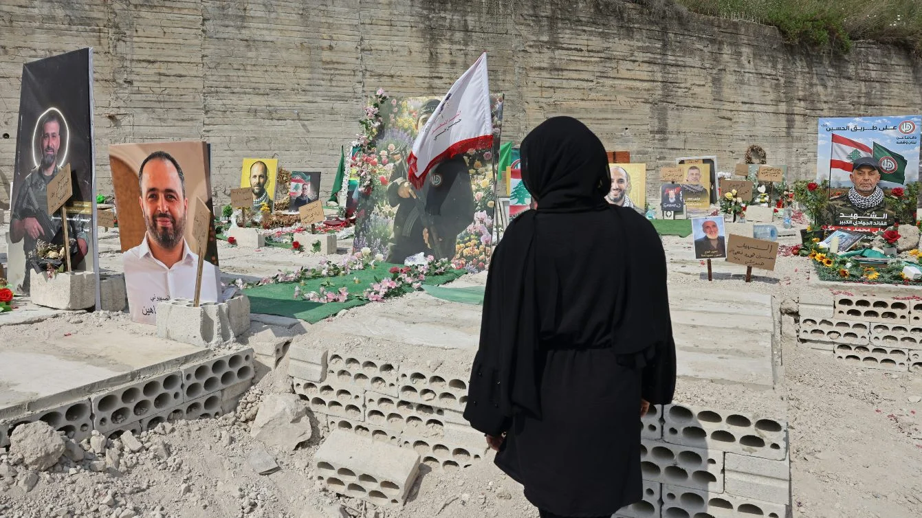 Woman sits inside temporary cemetery for Hezbollah fighters and civilians killed in war, in Sidon, Lebanon, 11 June 2026 (Anwar Amro/AFP)